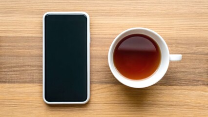 New Year Reset & Minimal Tech Lifestyle concept. Smartphone beside a cup of tea on a wooden surface, creating a cozy atmosphere for relaxation or work.