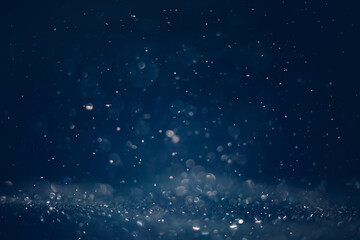 Bokeh snowfall on dark blue background