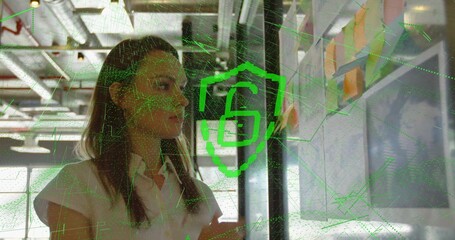 Arranging woman reviewing colorful sticky notes on whiteboard in office with padlock grid overlay