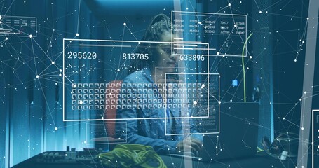 Typing IT specialist wearing denim jacket in server room with laptop, cables, holographic overlays