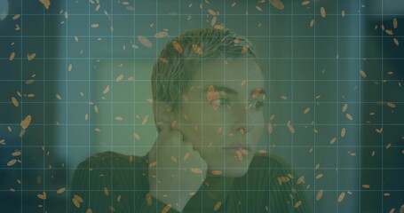 Sitting man holding chin on fist while gazing right in office chair, with blinds, grid, seeds