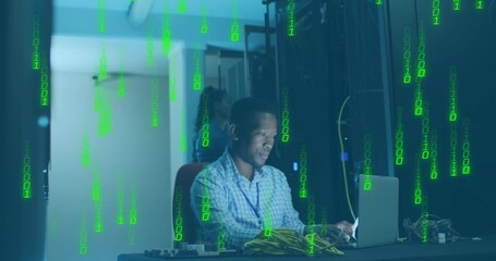 IT tech wearing checkered shirt, lanyard monitoring servers on laptop in server room, server racks