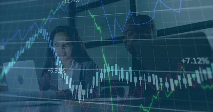 Two analysts in business attire analyzing charts on laptop in conference room, with chart overlays