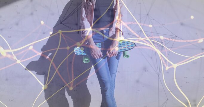 Casually dressed woman holding cruiser skateboard in studio with grey wall, network graph overlay - Powered by Adobe