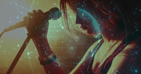 Singing teen holding microphone on stage, wearing necklace, wristwatch with digital globe overlay