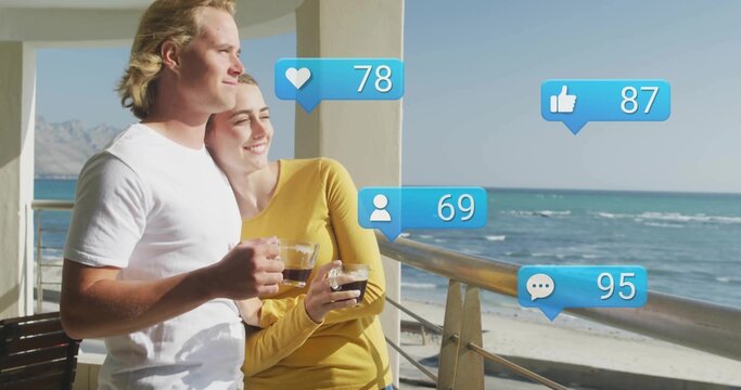 Leaning couple sipping coffee on beachside balcony, heart78 thumbs up87 user69 comment95 icons