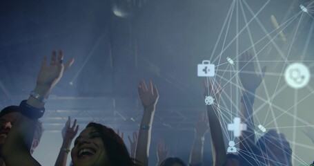 Cheering female attendee raising hands at concert hall, with wristband and digital network overlay © vectorfusionart