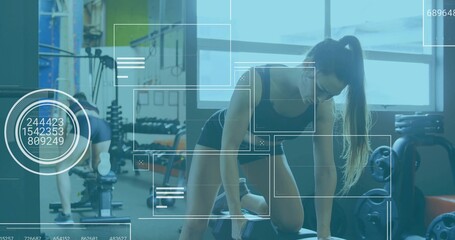 Kneeling woman in sportswear performing one-arm dumbbell row at gym, with weight bench and plates