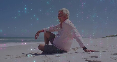 Relaxing senior man leaning back on sandy beach near water's edge, with wristwatch and ocean waves