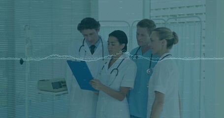 Reviewing patient notes medical team consulting at hospital ward, with blue clipboard, stethoscopes