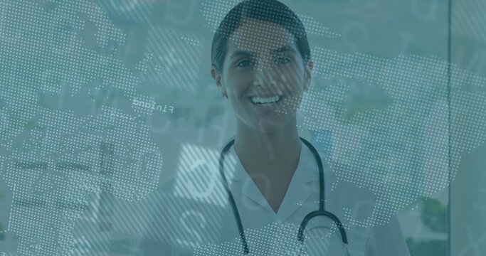 Smiling doctor standing at hospital glass panel, with stethoscope and digital map
