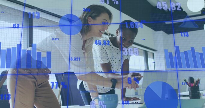 Collaborating businesswomen analyzing data at office desk, with laptop smartwatch digital overlays
