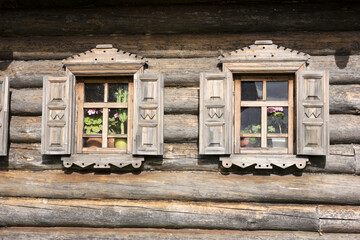 Windows of an old village house in exposition of tourist complex of village of Mandrogi. Russia