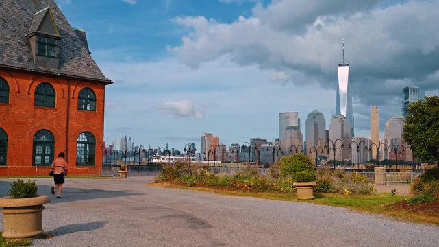 Man runs along the building of Central Railroad of New Jersey Terminal. Skyscraper skyline of Manhattan at backdrop.