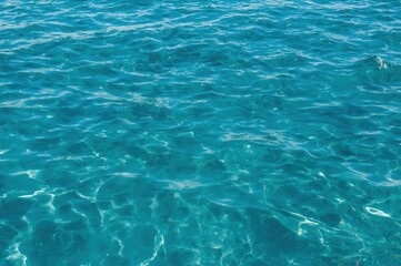 Obraz premium Gentle waves and shimmering reflections on a turquoise sea, A calming ocean backdrop