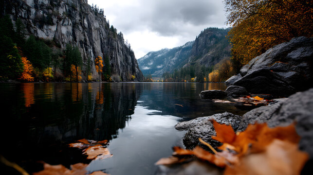 Quiet autumn scene with rustling leaves and calm waters under mountain cliffs.