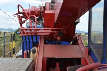 A detailed close-up of the complex hydraulic system, including hoses and fittings, on a piece of red, heavy machinery