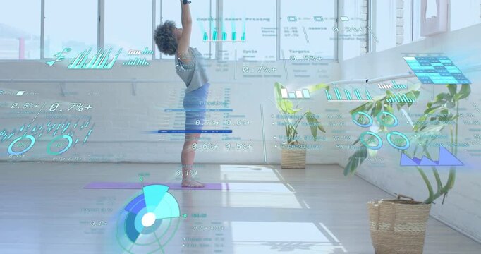 Yogi following on-screen prompts in health tech, lifting arms then backbending with live analytics