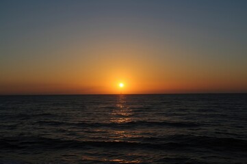 Obraz premium Spectacular ocean vista at sundown with a radiant sun illuminating the horizon over water