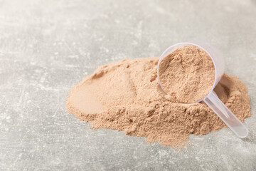 Protein powder. A spoonful of protein powder on a table. Different flavors of whey protein powder....