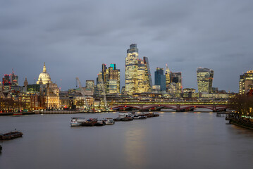 View of London skyline under cloudy sky at dusk in winter