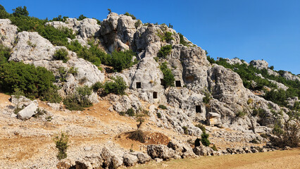 Rock-cut tombs in the necropolis on both sides of a valley to the north of the city, was used...