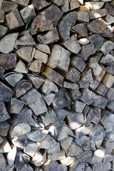  Stack of chopped firewood creating a rustic natural pattern. Rough wooden texture with sunlight and shadows. Perfect background for eco, rural, or countryside lifestyle concepts. High quality photo