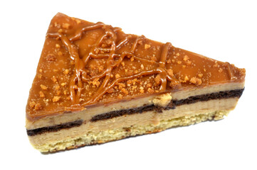 Biscuit creamy cake with layers of cake, whipped cream, biscuit paste and chocolate, a triangular piece of cake, celebration and holidays concept