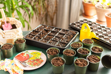 Starting tomato seeds indoors involves filling pots with soil, arranging containers, and organizing tools for a successful planting experience at home