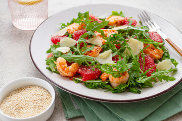 Fresh shrimp salad with arugula, grapefruit, and parmesan served in a bowl