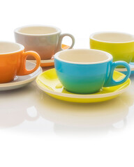 Set of colorful porcelain coffee cups and saucers on a white background. VERTICAL imagen. Copy space