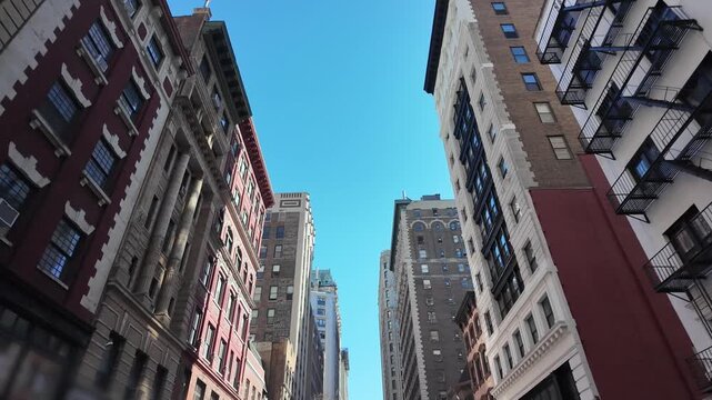 A slowly forward moving driving view of various buildings in the Flatiron NOMAD neighborhoods of midtown Manhattan on a crisp autumn sunny day. 14874  	
