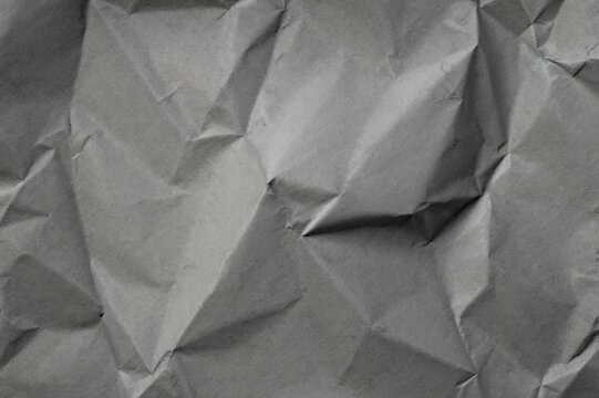Detailed abstract texture of crumpled gray paper with deep shadows and highlights.