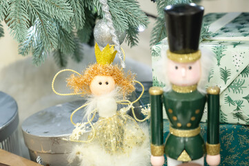 Close-up of a Gold and White Christmas Fairy Figurine Near a Nutcracker and Pine Branches