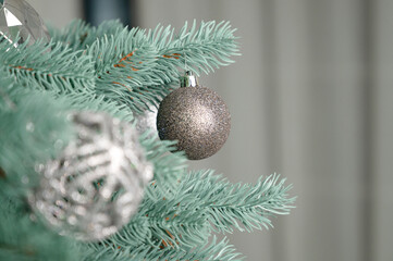 Macro Shot of a Glittery Silver Christmas Bauble Hanging on a Blue-Green Pine Branch