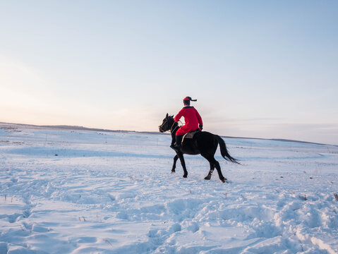 A Majestic Black Horse Rider Triumphantly Galloping through a Beautiful Snowy Landscape - Powered by Adobe
