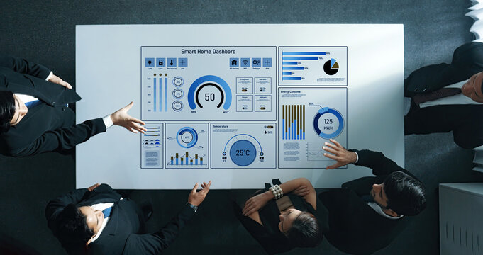 A business team engages in detailed analysis of a smart home dashboard displaying key data for energy management and decision-making processes within a contemporary office environment. Trope - Powered by Adobe