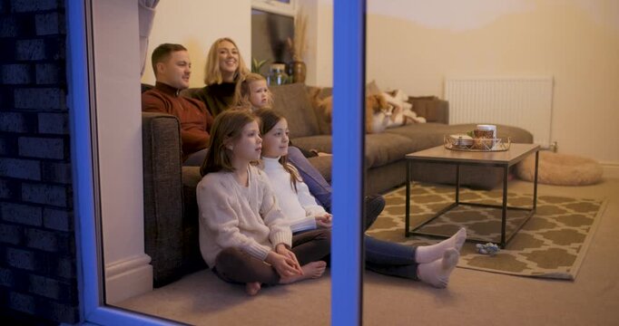 Happy family at home sitting on the sofa and watching tv