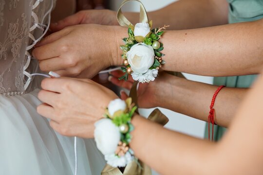 Wedding Day Preparations: Bride Having Corsage and Bracelet Applied. Cream Lace Dress, Floral Accessories, Gentle Touch, Romantic Scene, Soft Lighting