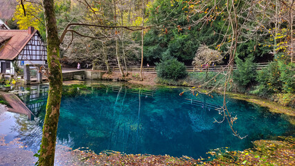 View of the small pond Blautopf with turquoise water in Blaubeuren, Germany in autumn day.