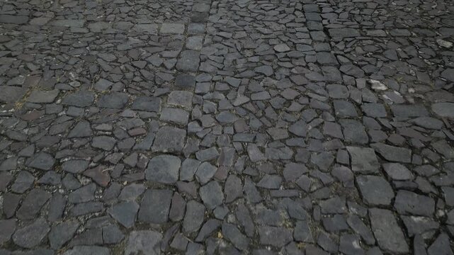 view of historic cobble stones on a small quiet street in antigua guatemala (colonial spanish style cobbles and cobblestone sidewalk) iconic construction street flying moving driving walking
