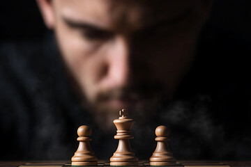 A strategist contemplates his next move in a game of chess, his intense focus highlighting the calculated nature of the game.