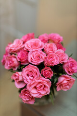 A beautiful bouquet of vibrant pink roses is arranged elegantly in a soft-focus setting.
