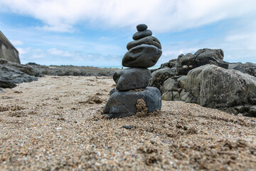 stones on the beach stacked one on top of the other, creating a stone tower