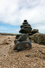 stones on the beach stacked one on top of the other, creating a stone tower