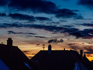 Sonnenuntergang hinter Funkmast und D&auml;chern