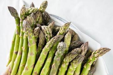 Fresh green asparagus on a plate invites you to savor its vibrant flavor and health benefits