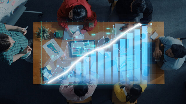 Business team collaborates in a modern office, analyzing financial growth with digital data overlay while discussing strategies and sharing insights effectively. Axiom