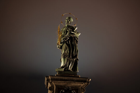 Statue of John of Nepomuk, Charles Bridge, Prague, Czech Republic, Czechia. Sculpture of saint historical person. Historic monument and landmark. Baroque artwork from 17th century. Copy space.