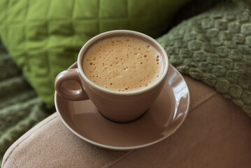 Cup of Hot Coffee Stay on Arm of Cozy Couch by Blanket